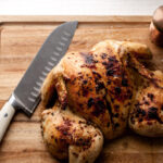 lemon garlic spatchcocked chicken on cutting board.