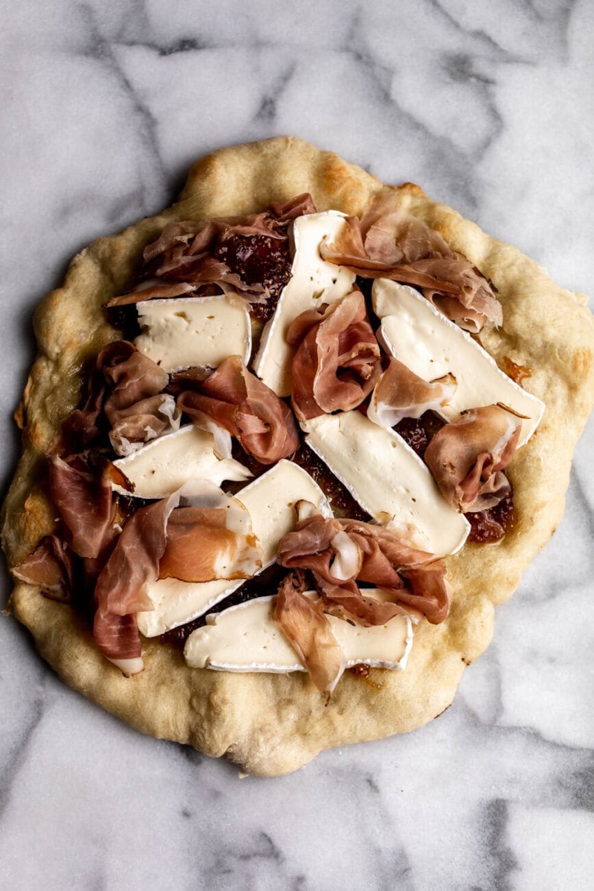 fig pizza with speck cured meat and brie cheese.