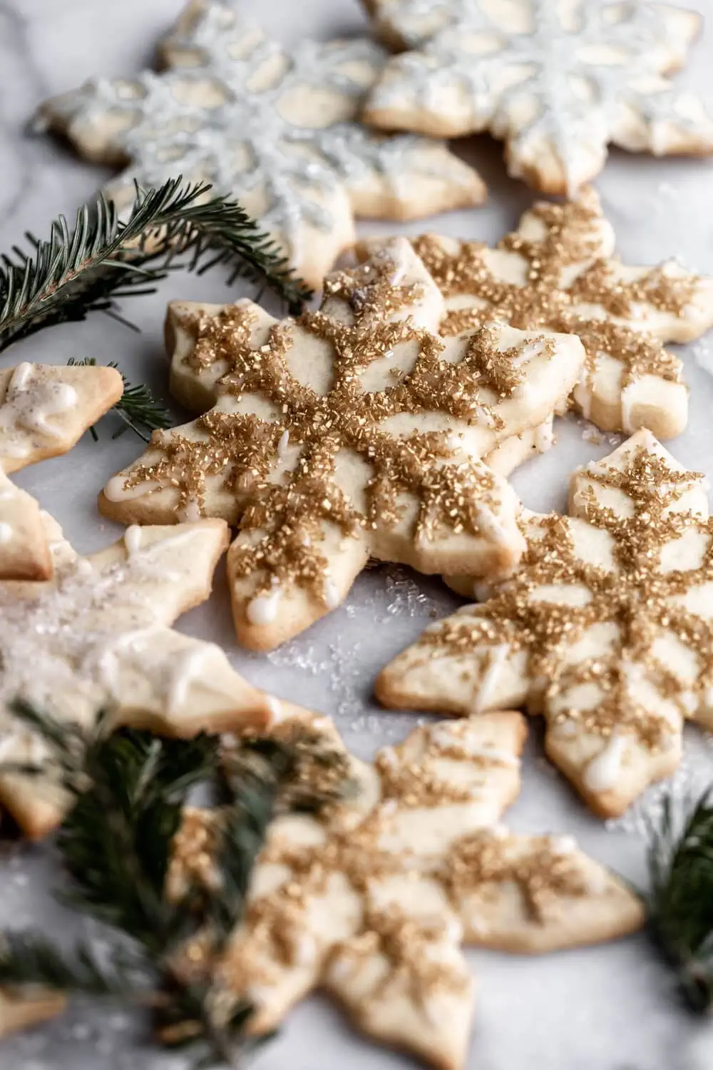 Sugar cookies snowflakes decorated with icing and gold and silver sprinkles