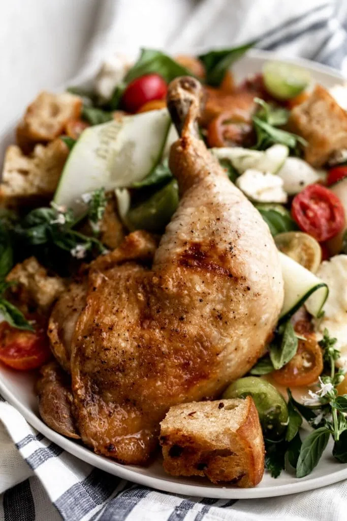 whole roast chicken leg over panzanella salad