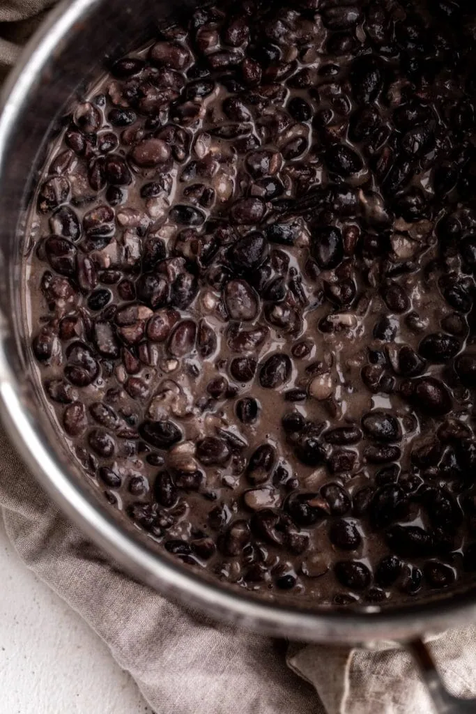 heated canned black beans in a sautcepan with spices