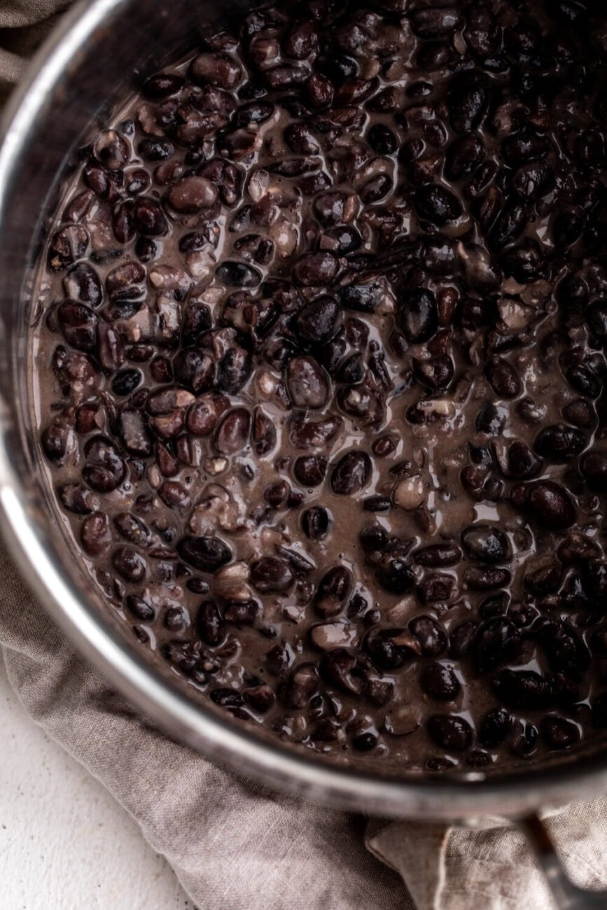 heated canned black beans in a saucepan with spices.