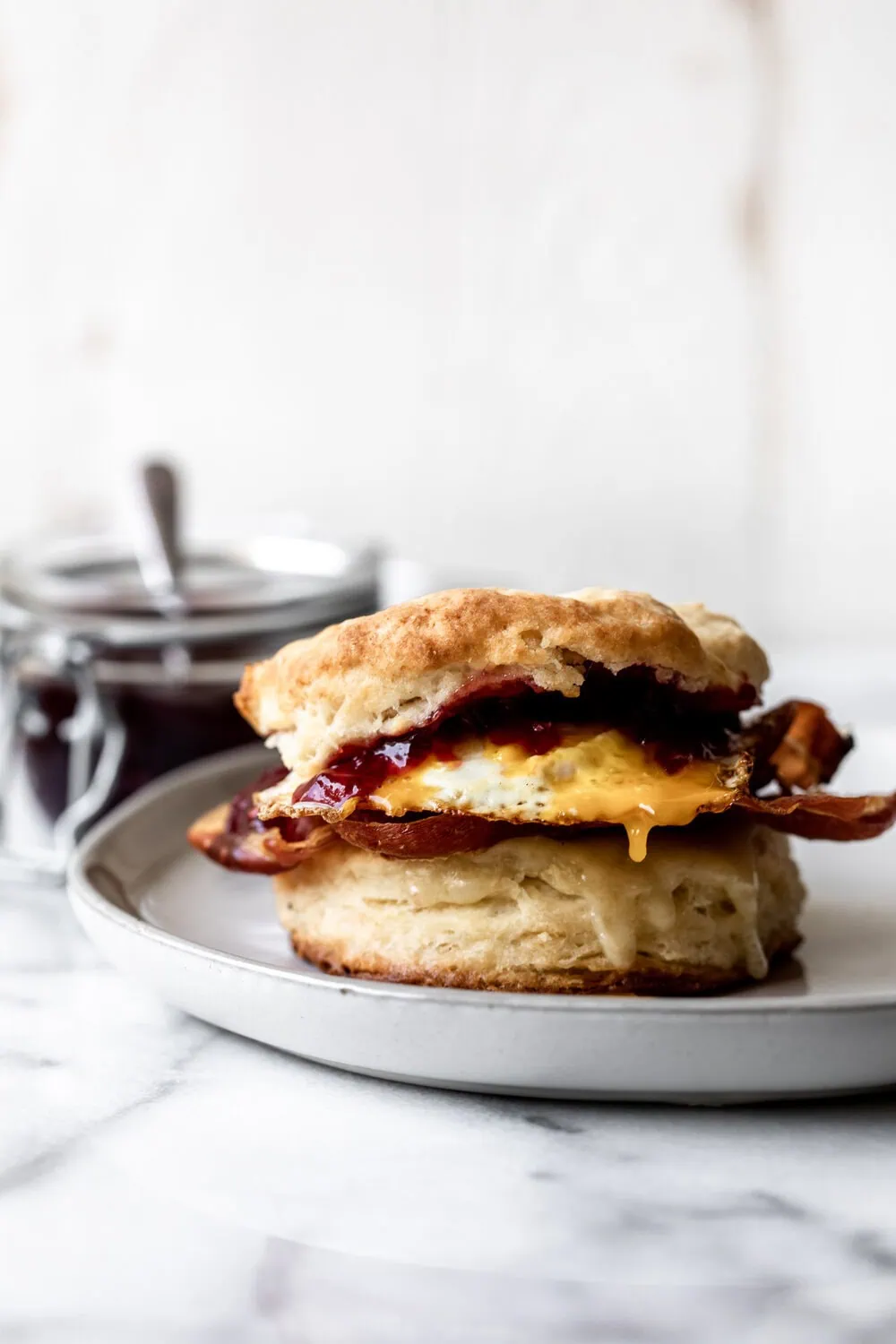 sweet and savory breakfast biscuit with crispy prosciutto, gruyere cheese, jam and a fried egg