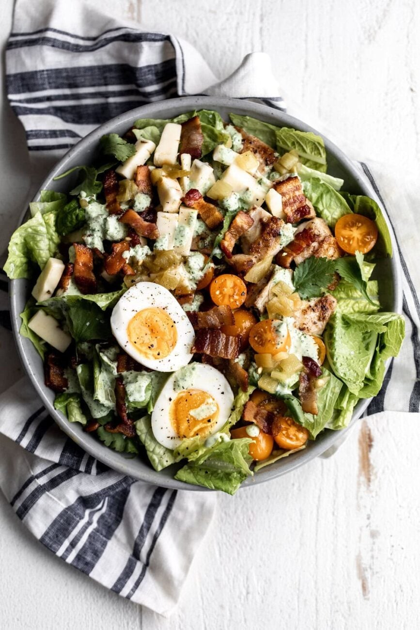 closeup of Tex-Mex Cobb salad 
chicken thighs, bacon, diced green chilies topped with soft-boiled eggs.