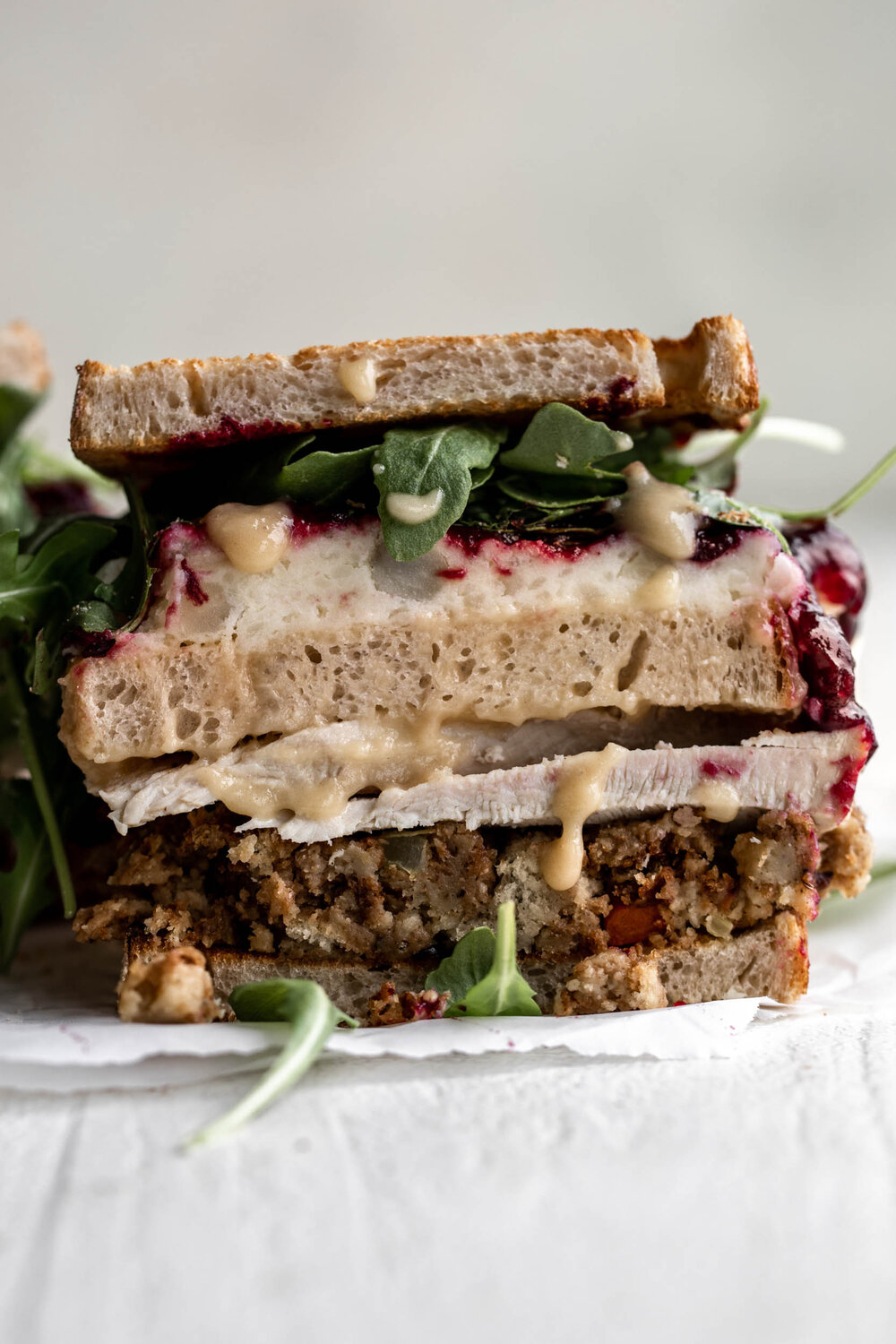 Thanksgiving Leftover sandwich the Moistmaker Sandwich (from Friends the tv show) with a middle slice of bread soaked in gravy, cranberry sauce, mashed potatoes, stuffing, turkey and arugula