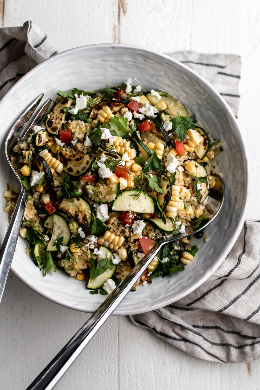 This summer quinoa salad recipe is packed with seasonal ingredients like zucchini, corn, tomatoes in this vegetarian dish.