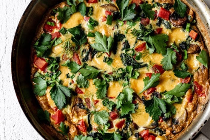 veggie frittata with fresh chopped herbs and tomato.
