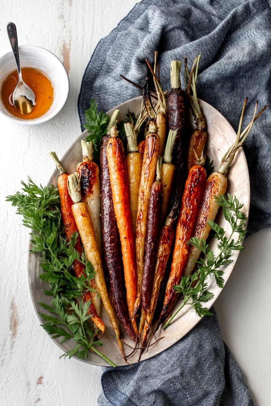 Whole honey glazed carrots on a platter.