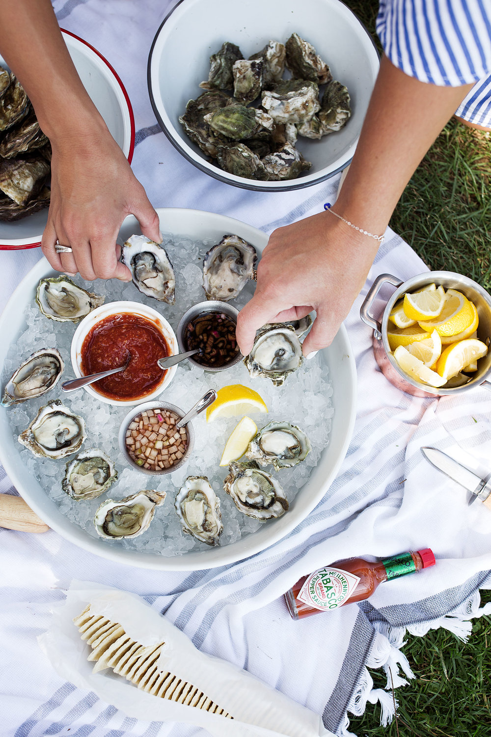 reaching for oysters from platter