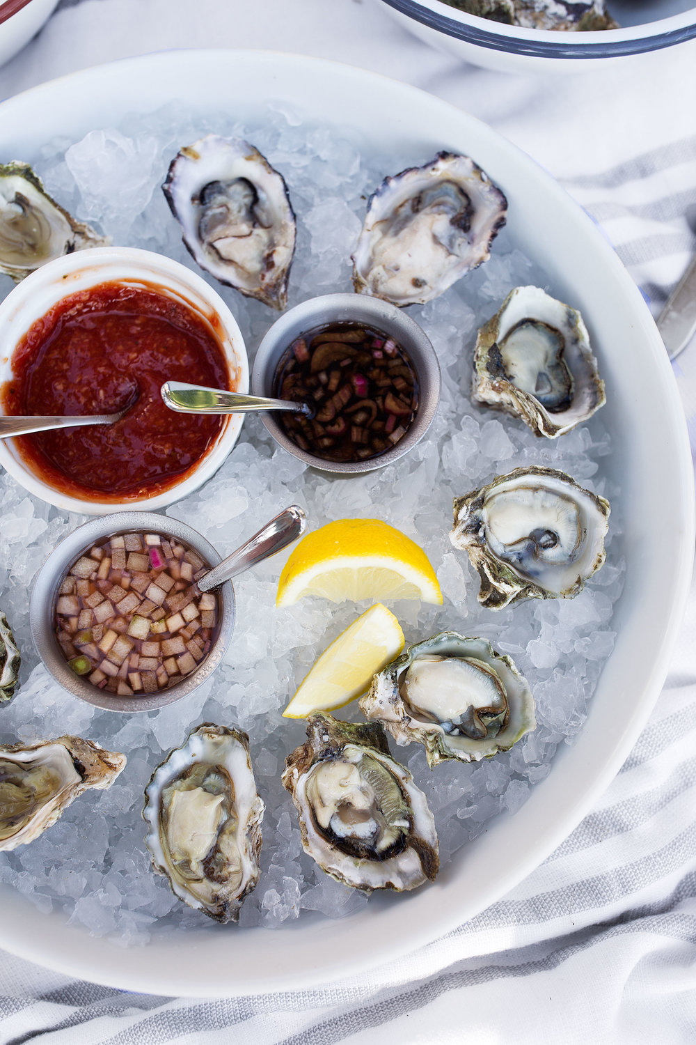 oysters on serving platter with oysters mignonette lemons and cocktail sauce