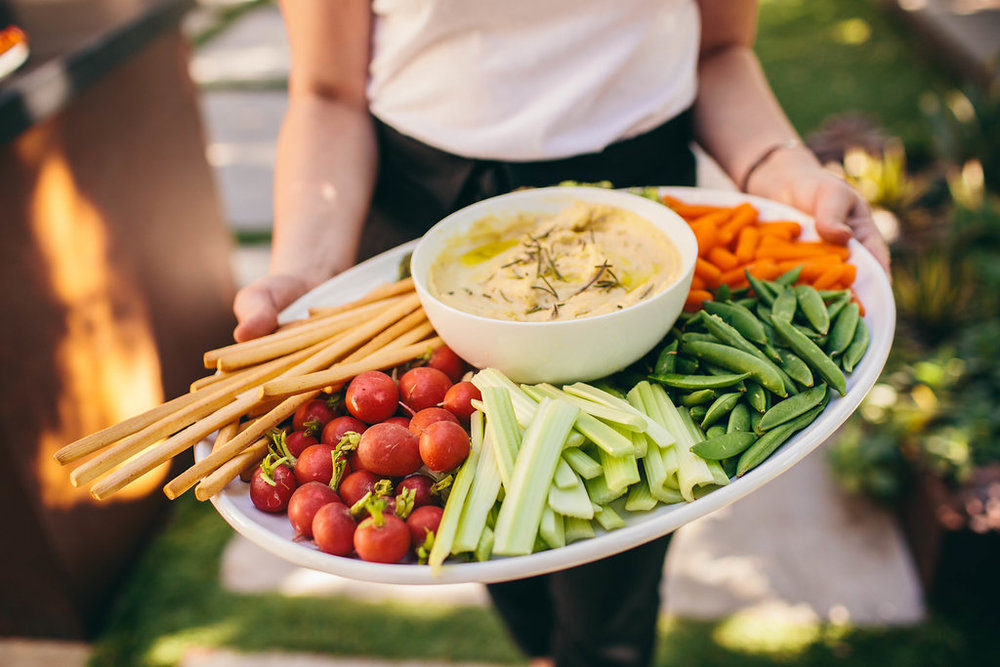 Kylie Mazon-Chambers holding white bean rosemary dip and veggies