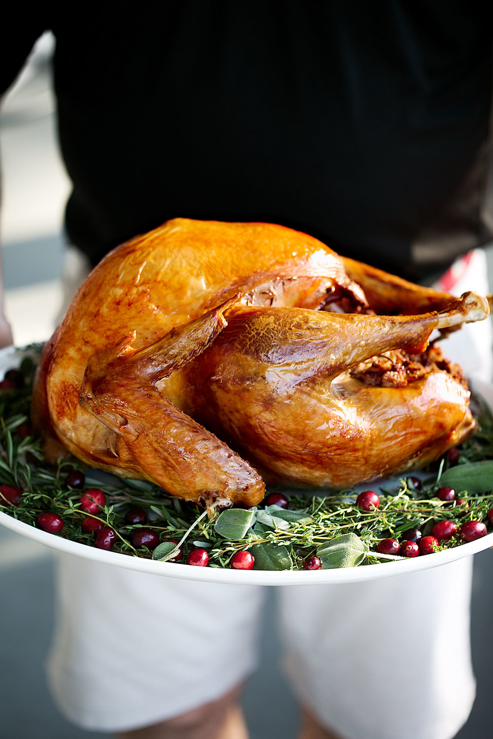 Herb-Brined Turkey with Classic Stuffing on white platter Thanksgiving dinner