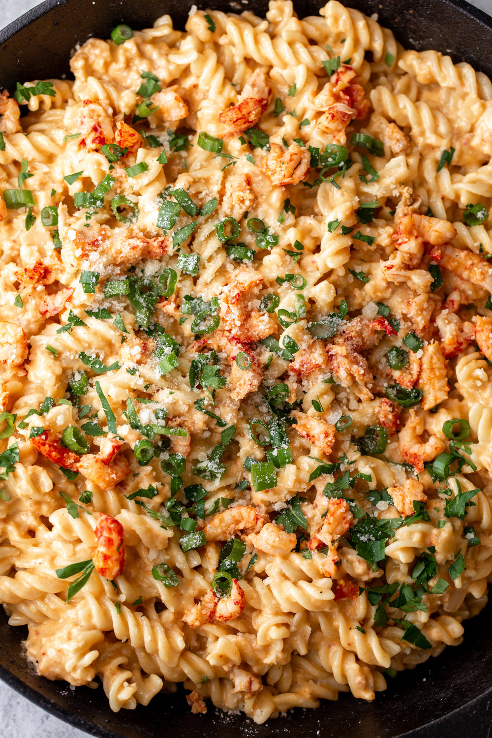 cajun crawfish mac and cheese recipe topped with green onion and chopped cilantro