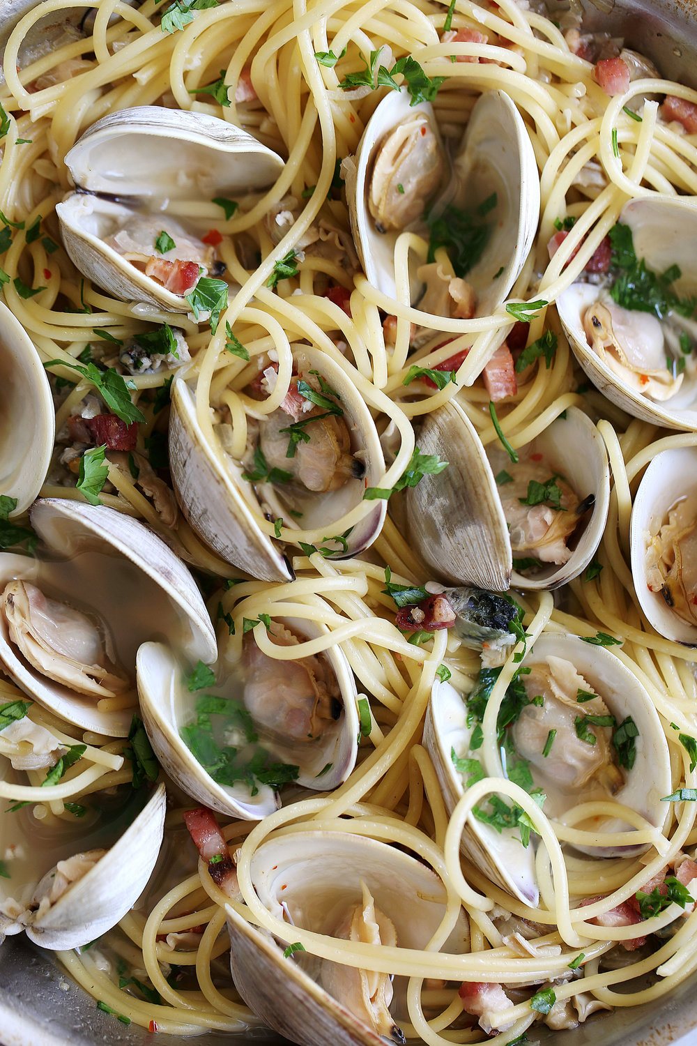 spaghetti alle vongole steamed clams opened with pancetta garnished with parsley