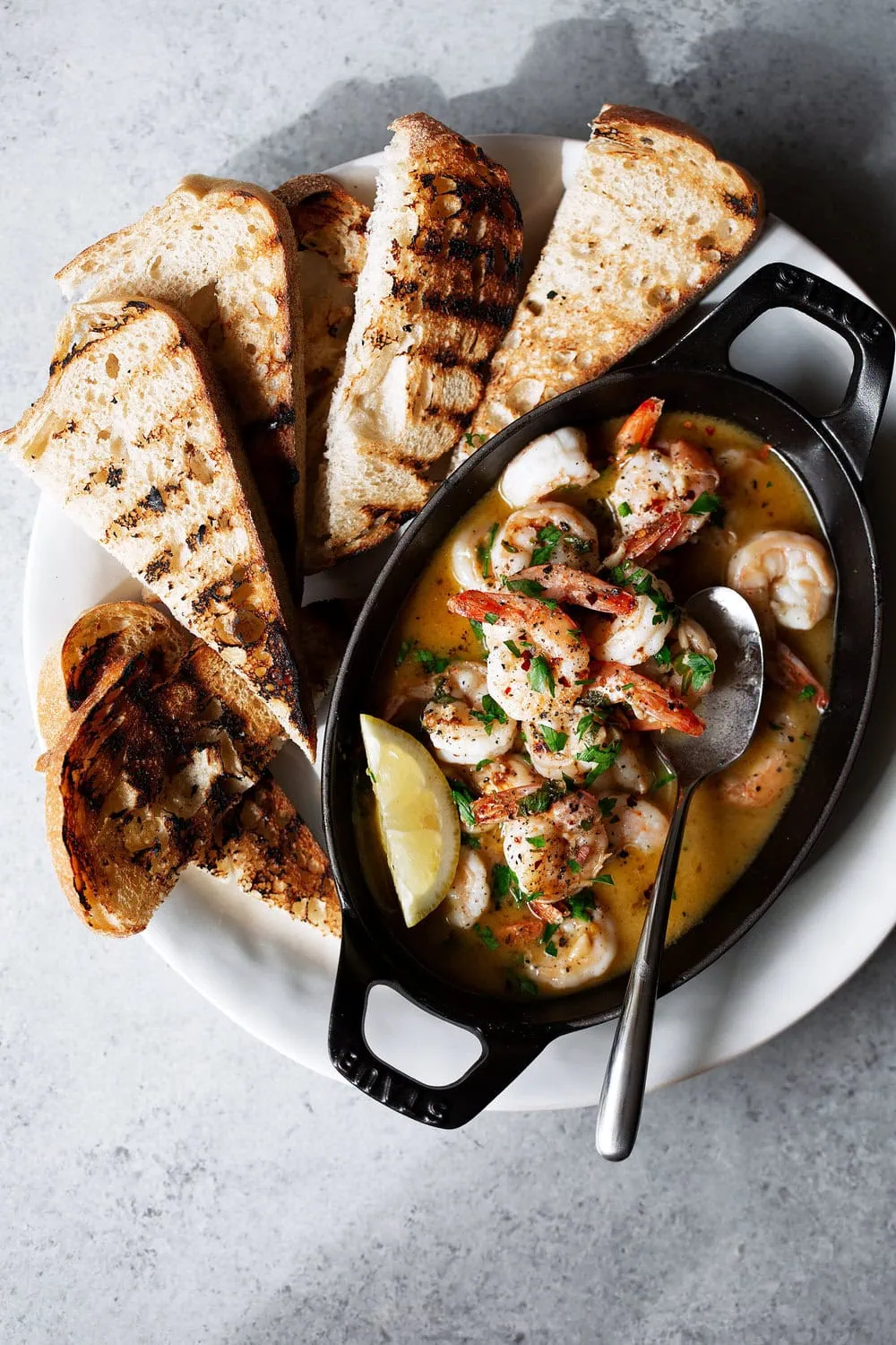 shrimp scampi toasts appetizer recipe in staub baking dish with grilled bread