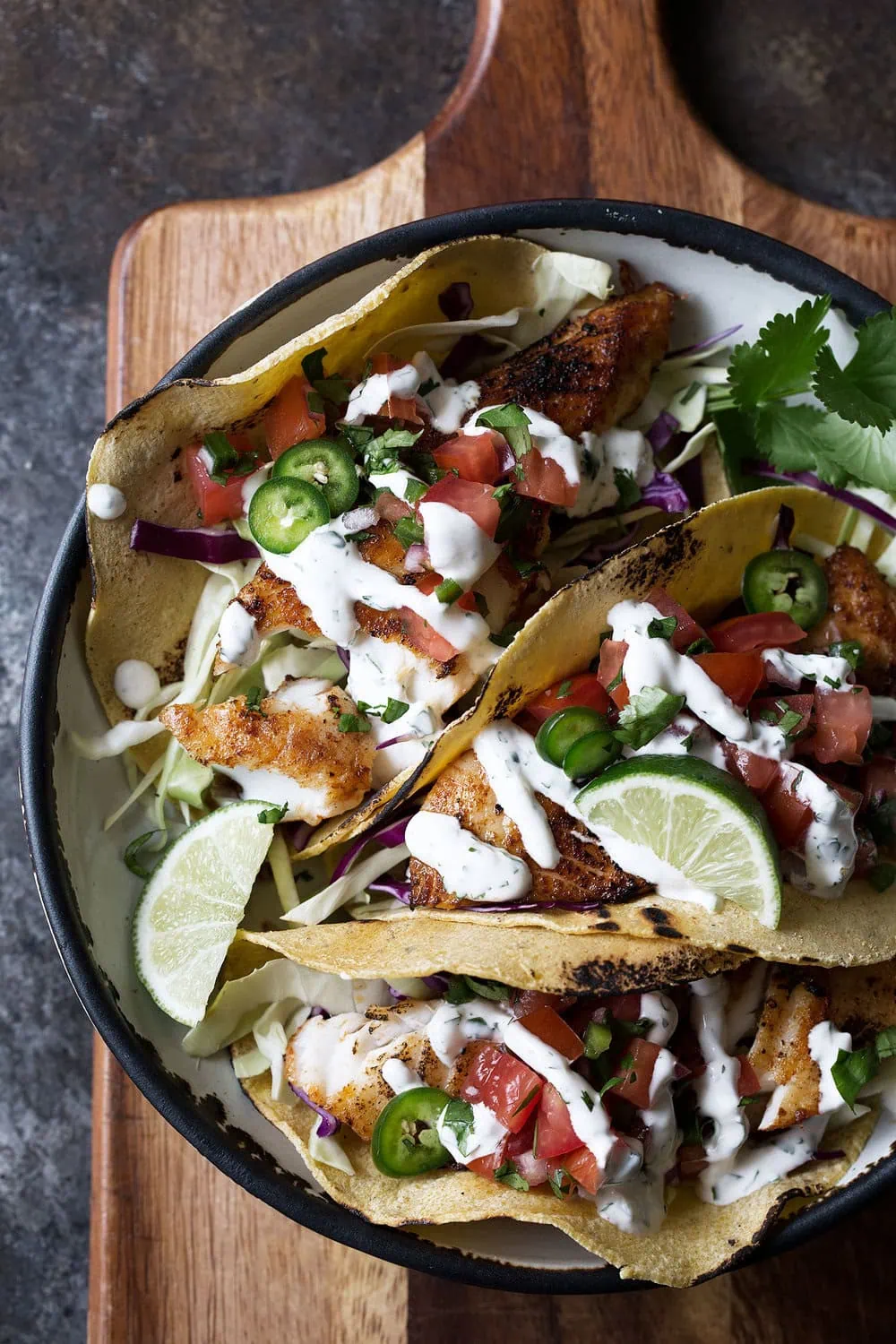 pan-fried seasoned fish tacos with cilantro lime sauce in corn tortillas with pico de gallo
