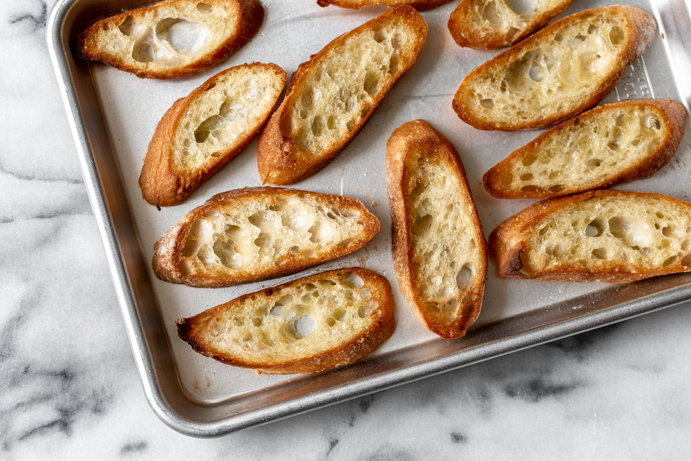 toasted baguettes crostini on baking sheet