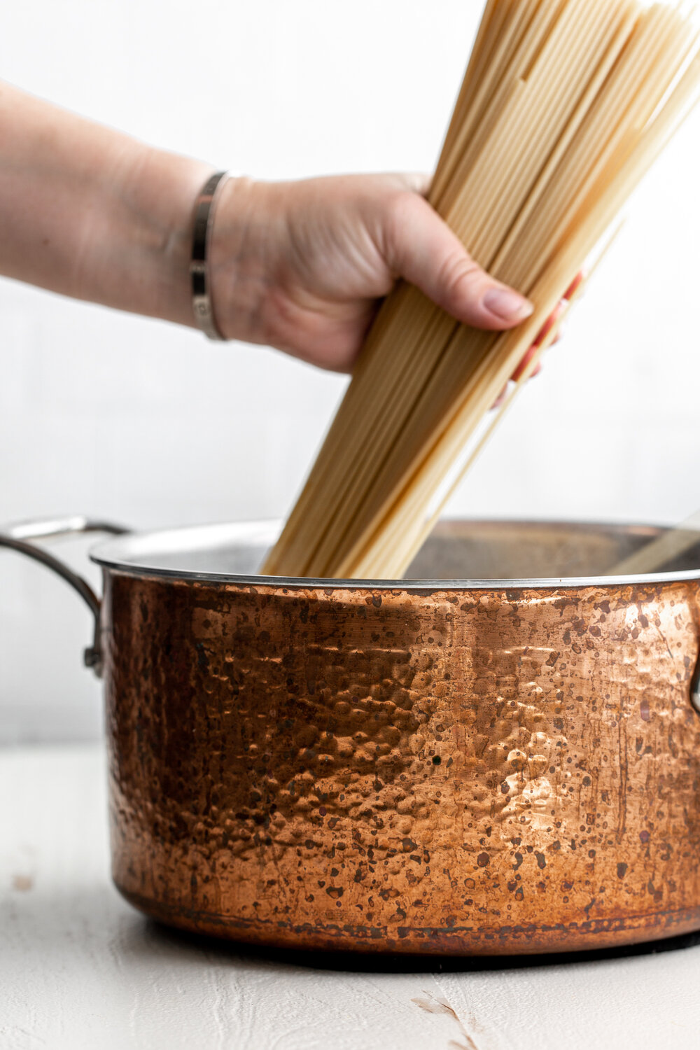 cooking bucatini pasta in copper pot