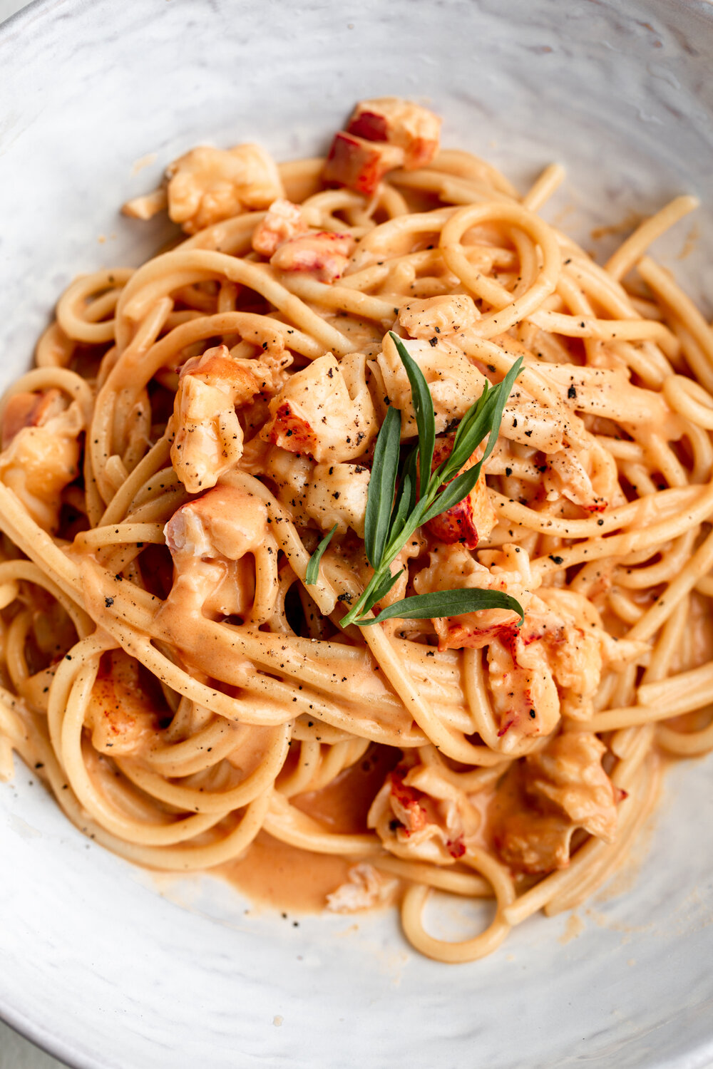 creamy lobster pasta with lobster bisque sauce recipe garnished with fresh tarragon