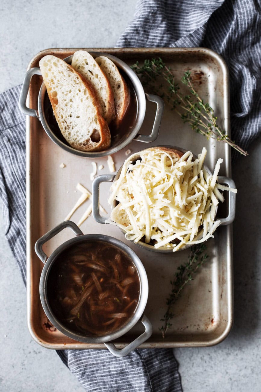 french onion soup topped with bread and cheese in small pots.