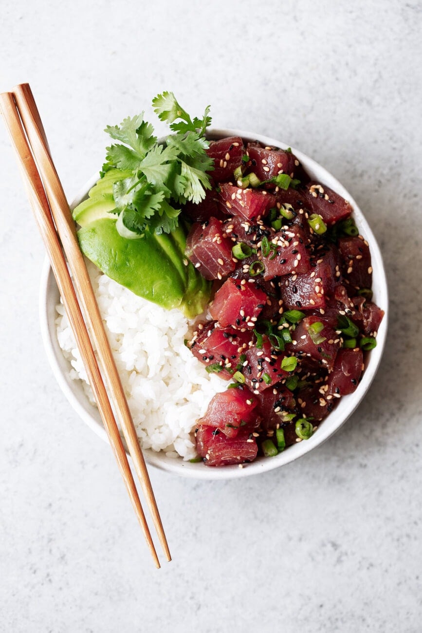 Hawaiian Ahi Tuna Poke recipe with avocado over white rice with chopsticks.