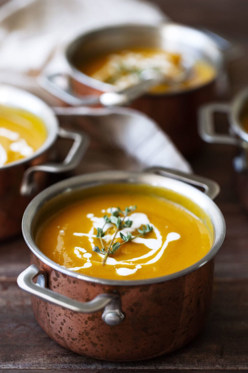 Butternut Squash Soup with Maple Cream in small copper pots.
