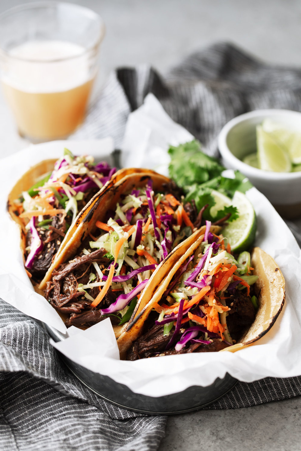 Braised Korean BBQ Beef Tacos topped with broccoli and cabbage slaw in parchment paper