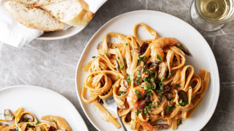 This sun dried tomato cream sauce comes together with just a few ingredients and is served with sautéed mushrooms and shrimp over fettuccine for an easy Mediterranean-inspired pasta dinner. The recipe is based off a dish at Tony’s Taverna in Malibu.