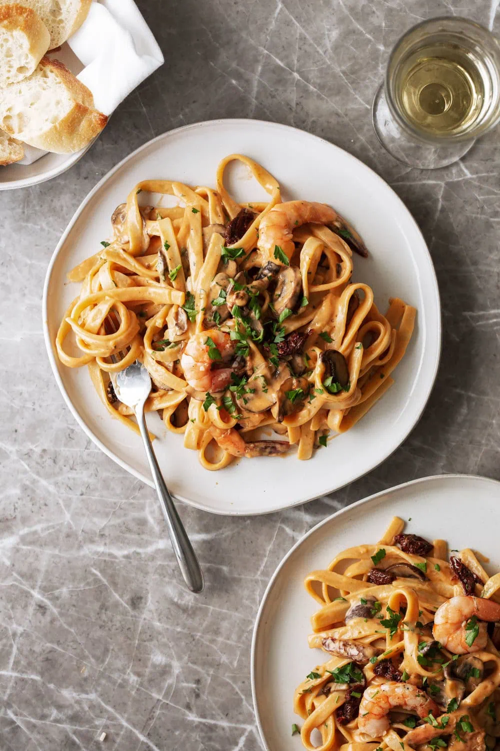 A bowl of creamy shrimp pasta with sun-dried tomato sauce, topped with Parmesan.