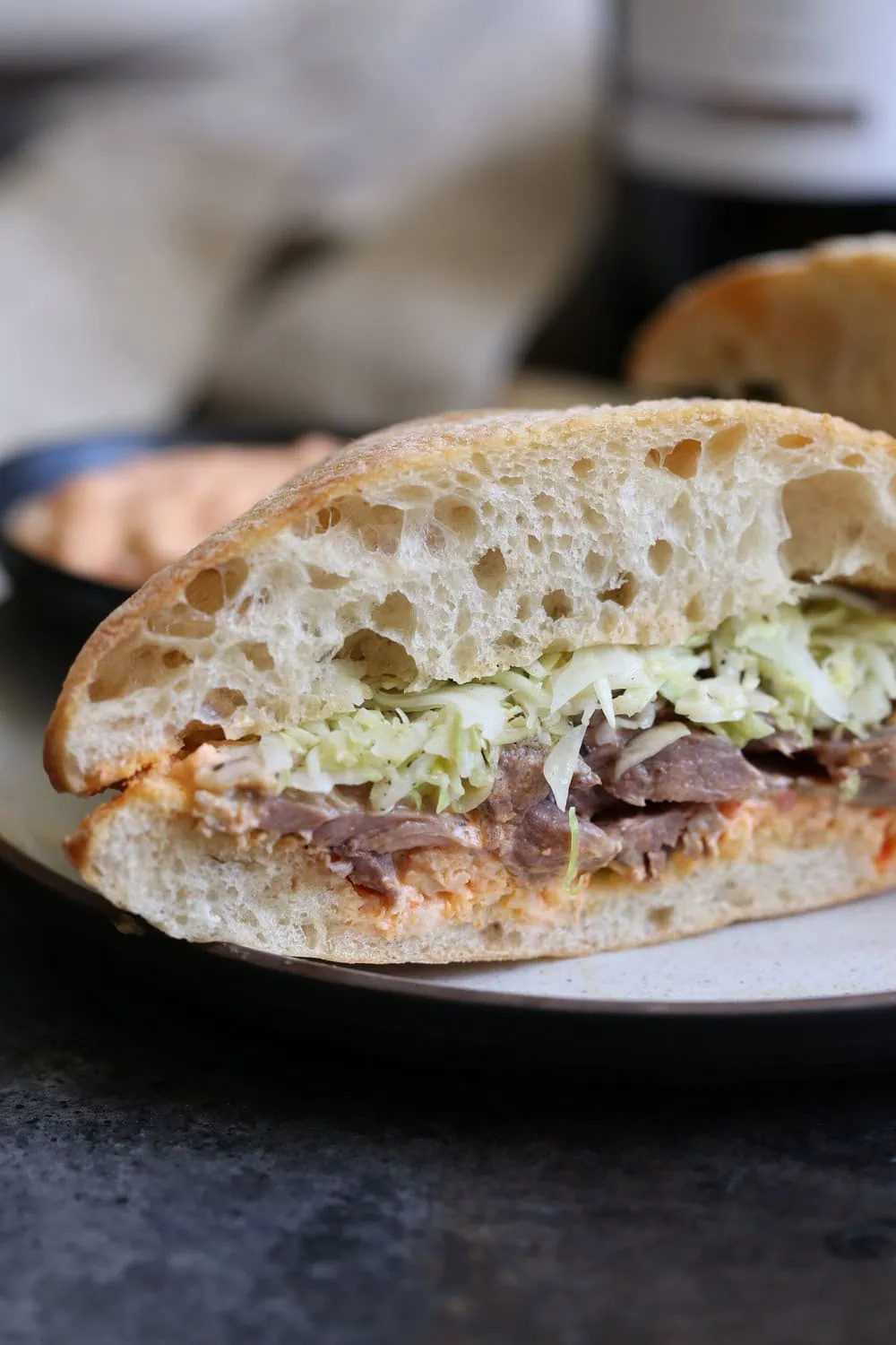 Greek Lamb Sandwich with Harissa Yogurt Sauce cut in half