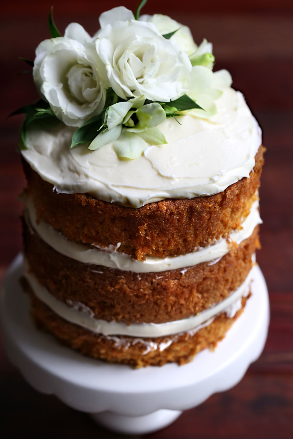 carrot cake layer cake with cream cheese frosting and flowers
