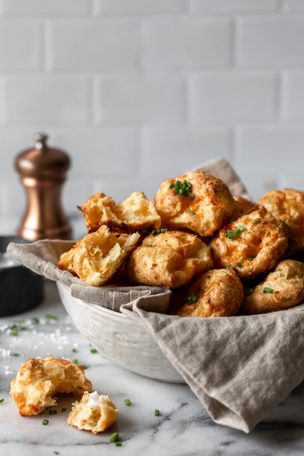 lobster cheddar Gougeres recipe garnished with chives in bowl