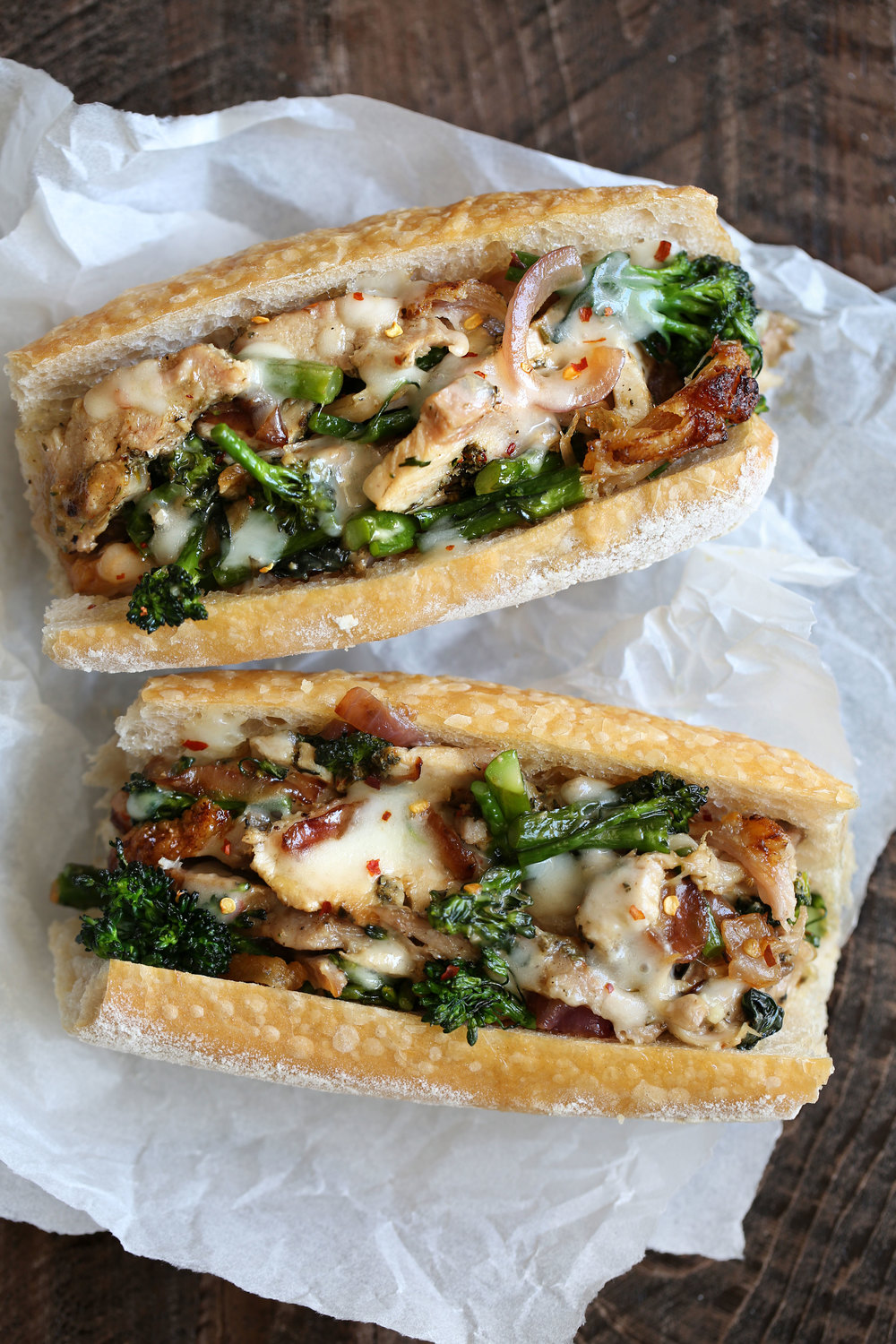 porchetta sandwich with melted cheese grilled onions and broccolini
