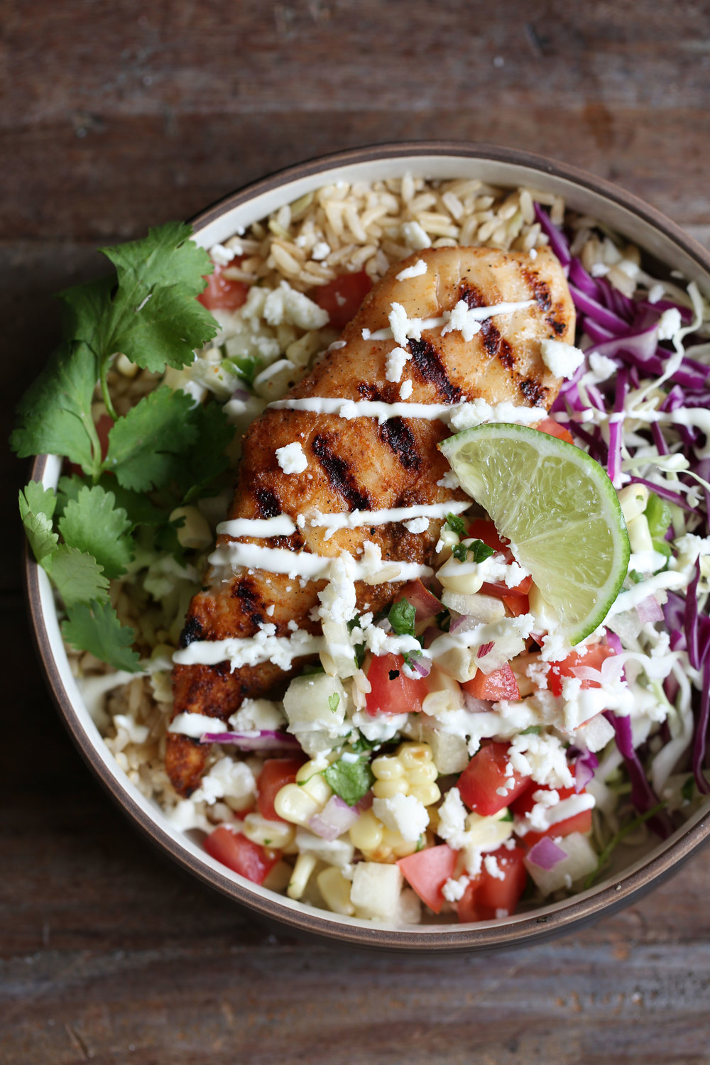 grilled fish taco rice bowl over cabbage and rice with jicama salsa and lime