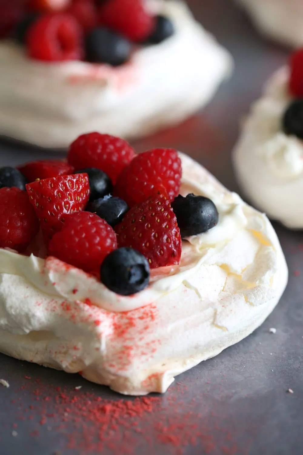 mini pavlovas with mixed berries dusted with freeze dried strawberry powder