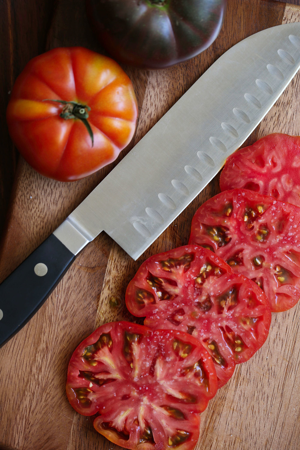 sliced heirloom tomatoes on cutting board 