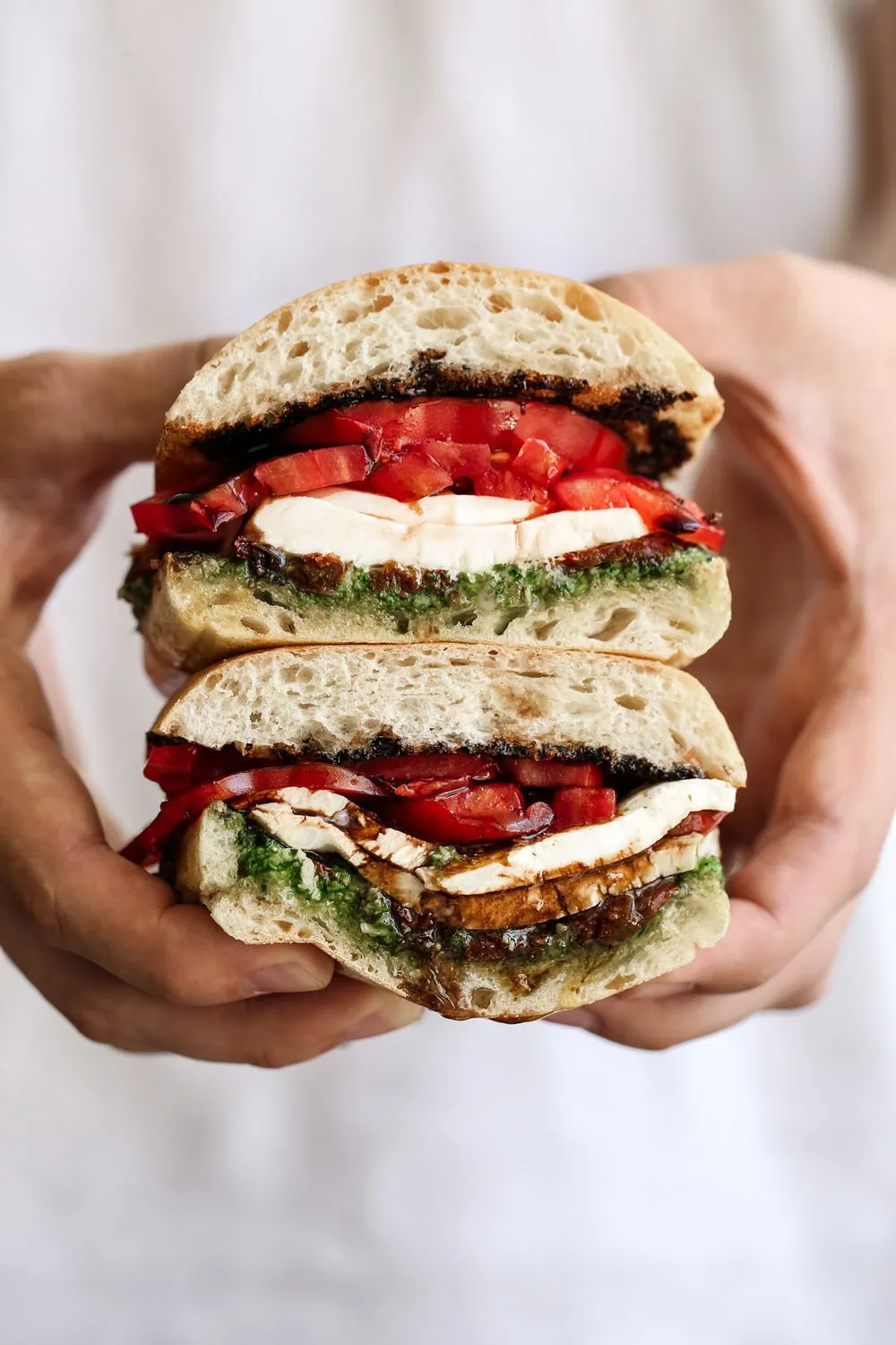 Caprese sandwich with ciabatta bread with fresh pesto, sun dried tomatoes, mozzarella cheese, heirloom tomatoes and balsamic glaze