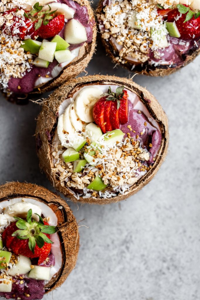 acai smoothie bowl served in opened coconuts