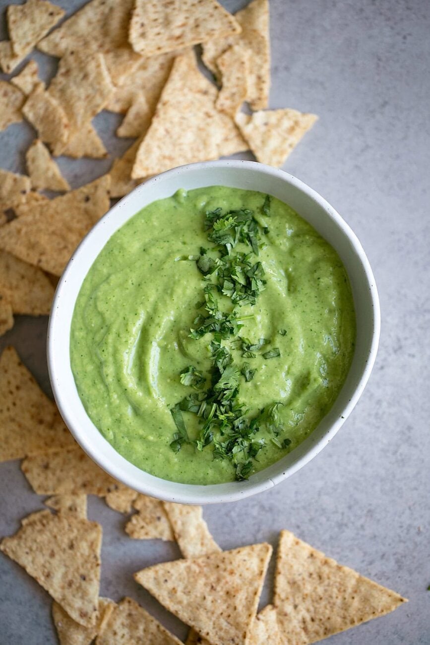 Avocado tomatillo salsa verde topped with chopped cilantro. Chips on the side.