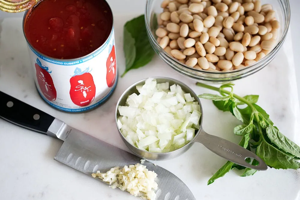 white bean kale tomato soup ingredients on cutting board