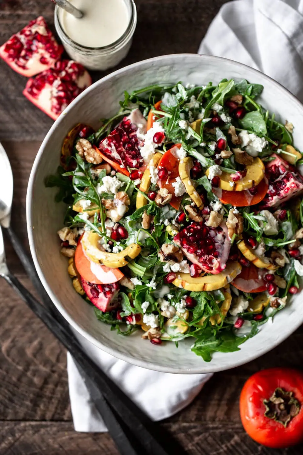fall roasted squash salad with yogurt-tahini dressing with arugula pomegranate walnuts and persimmon