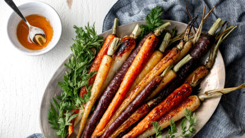 Whole honey glazed carrots on a platter.