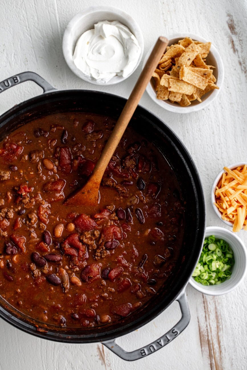 classic beef chili in pot with toppings on the side.