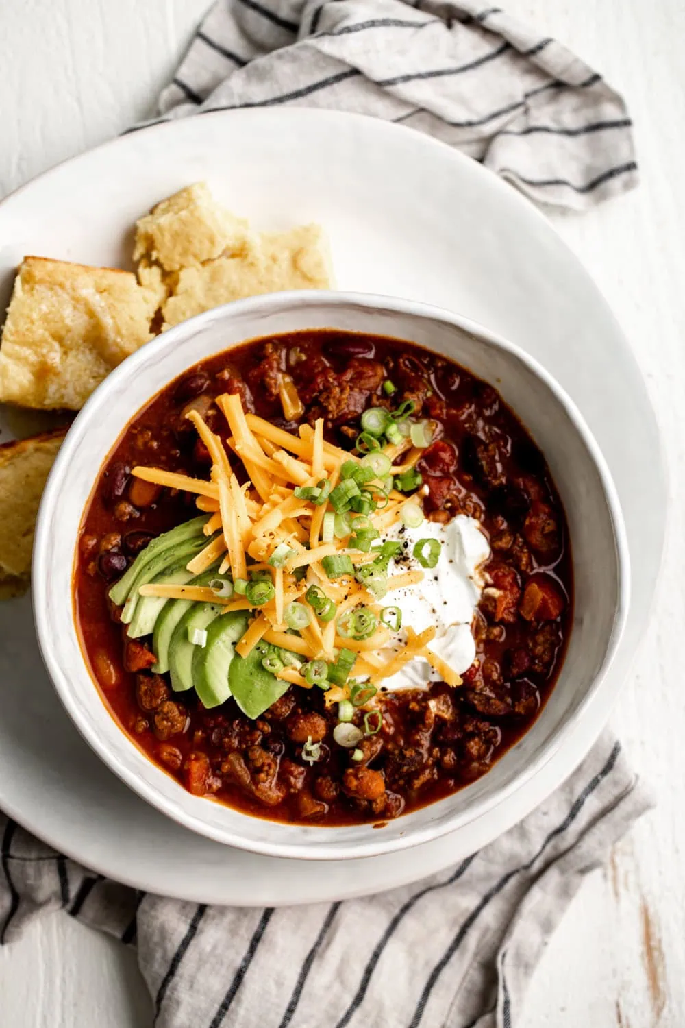 classic beef chili with sour cream cheddar cheese avocado and green onion with side of cornbread