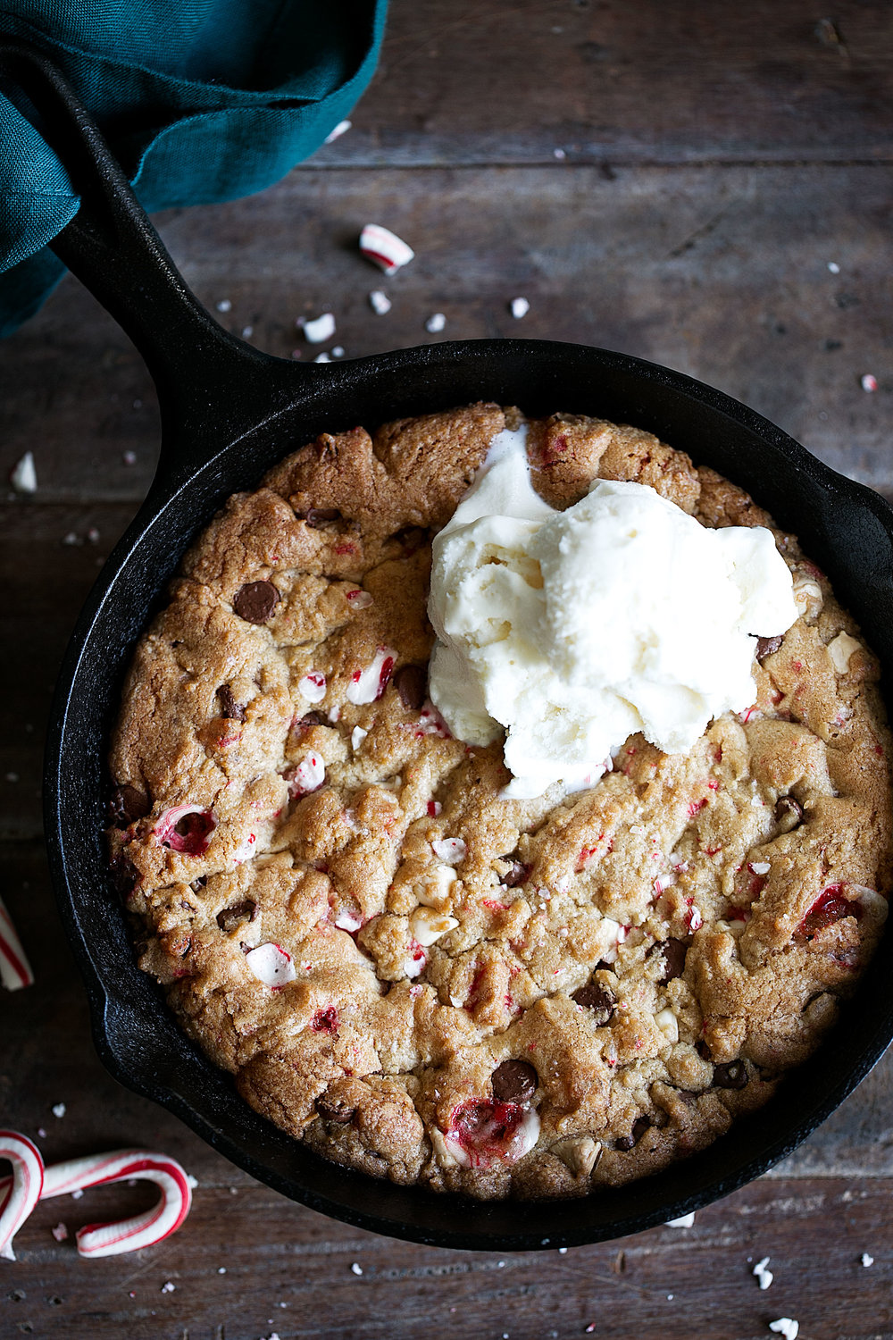 peppermint mixed chocolate chip skillet pizza cookie with scoops of vanilla ice cream