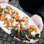 baked stuffed shrimp with crabmeat filling on white platter.