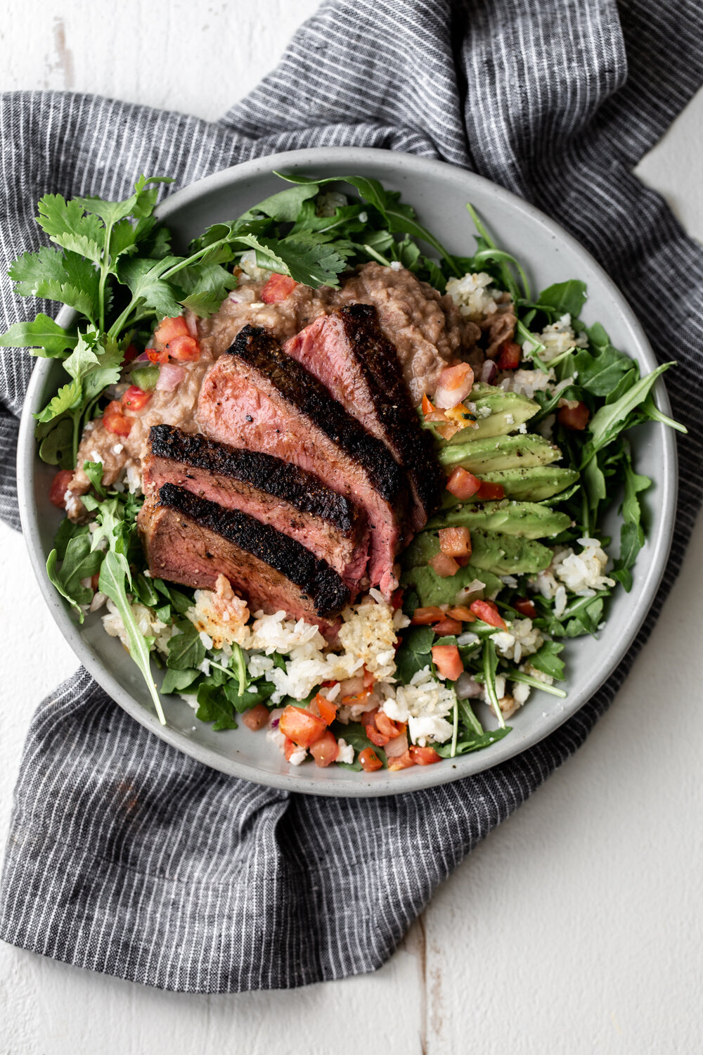 Seared Steak with Refried Pinto Beans, Crispy Rice and Arugula recipe from cooking with cocktail rings