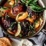 balsamic skin on chicken thighs in a saute pan with peaches and basil