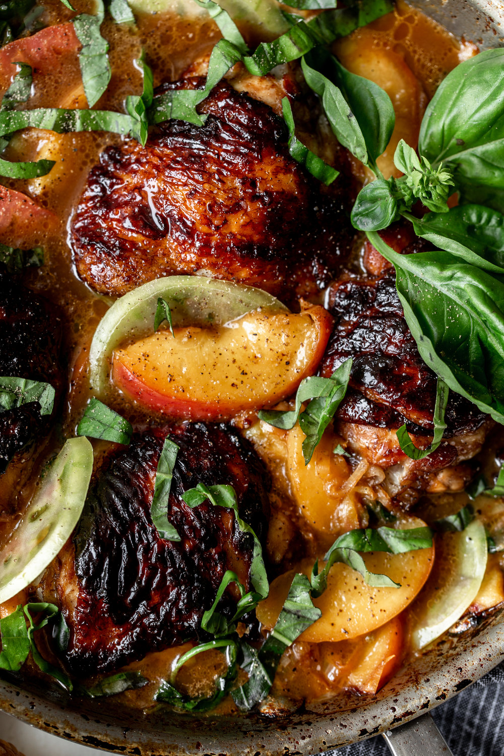 Honey Balsamic Chicken Thighs with Peaches and tomato recipe garnished with basil