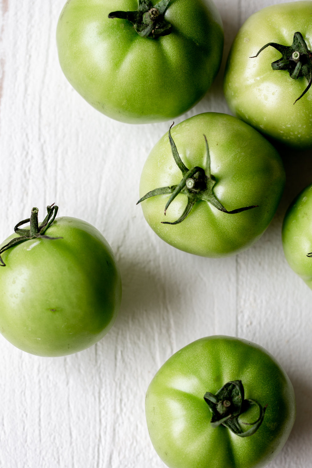 Green tomatoes on white board